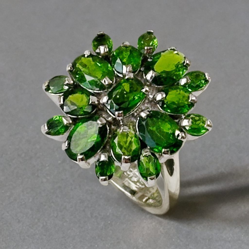 Ring with green gemstones on a gray background
